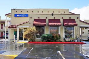 un magasin avec des auvents rouges sur une rue pluvieuse dans l'établissement Americas Best Value Inn - Milpitas, à Milpitas