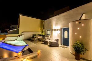 a villa with a swimming pool at night at Amera Suites in Fira