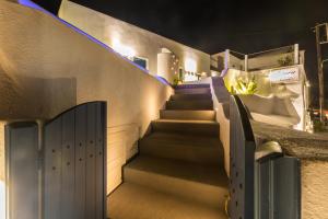 a set of stairs leading up to a building at night at Amera Suites in Fira