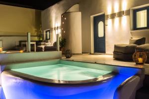 ein Pool mit blauen Lichtern in einem Haus in der Unterkunft Amera Suites in Fira