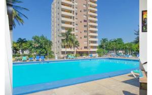 a large swimming pool in front of a tall building at Coconut Shell At Turtle Towers in Ocho Rios +8 photos