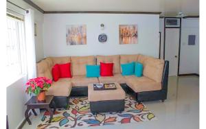 a living room with a couch with red and blue pillows at Coconut Shell At Turtle Towers in Ocho Rios