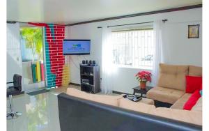 a living room with a couch and a tv at Coconut Shell At Turtle Towers in Ocho Rios