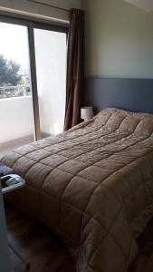 a bed in a bedroom with a large window at Апартаменты Ирина М in Bar