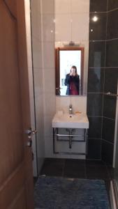 a person taking a picture of a sink in a bathroom at Апартаменты Ирина М in Bar +22 photos