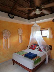 a bedroom with a bed and a window at Casa Abanico Tulum in Tulum
