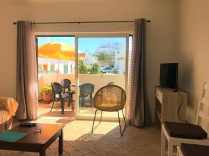 a living room with an open door to a patio at Casas da Vila in Luz