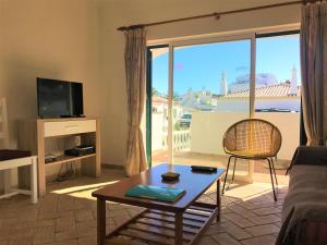 un soggiorno con un divano, un tavolo e una TV di Casas da Vila a Luz