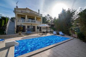 a villa with a swimming pool in front of a house at Villa Napolia in Zakynthos