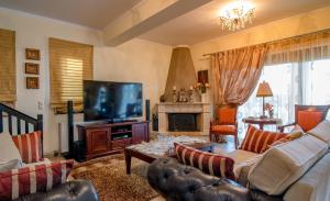 a living room with couches and a flat screen tv at Villa Napolia in Zakynthos Town