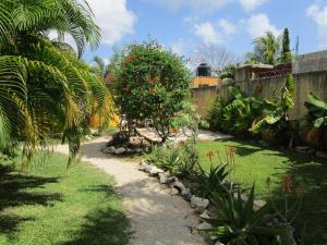 a garden with a tree with red flowers on it at Casa Abanico Tulum in Tulum