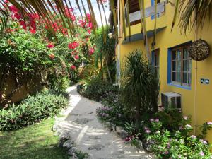a garden with flowers and a yellow building at Casa Abanico Tulum in Tulum