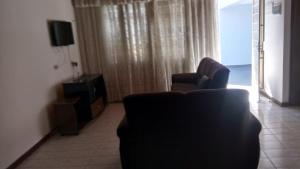 a living room with two chairs and a window at Vista Bela in Campos do Jordão