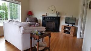 a living room with a white couch and a television at Charming, Private Cottage in Myrtle Creek in Myrtle Creek