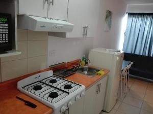 a kitchen with a stove and a white refrigerator at MV Suites in Monterrey