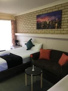 a hotel room with a bed and a couch at Jolly Swagman Motor Inn in Goondiwindi