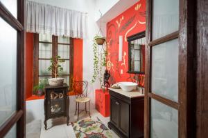 uma casa de banho com um fogão e uma parede vermelha em La Casona de Tete em Lagos de Moreno