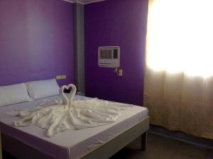 un cisne blanco sentado encima de una cama en UKL Ever Resort Hotel, en Laoag
