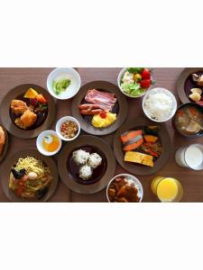 una mesa llena de diferentes tipos de comida en platos en Almont Inn Shonan Fujisawa, en Fujisawa