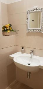 bagno con lavandino bianco e specchio di Hotel Basilea a Bellaria-Igea Marina