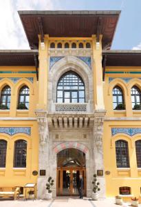 żółty budynek z mężczyzną stojącym przed nim w obiekcie Four Seasons Hotel Istanbul at Sultanahmet w Stambule