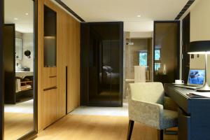 台北市にあるマディソン タイペイ ホテルのデスク、椅子、ドアが備わる客室です。