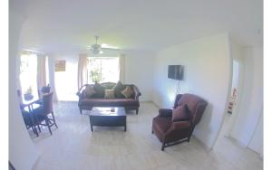 a living room with two couches and a table at Beach Side Suite At Turtle Towers in Ocho Rios