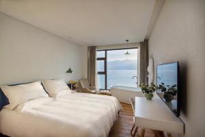 TV a/nebo společenská místnost v ubytování 大理远山青Stone Hill悬崖海景民宿 Dali Verdant Whisper-Stone Hill Seaview Inn
