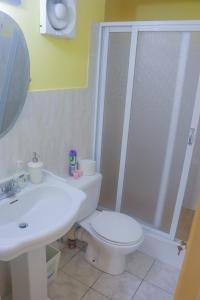 a bathroom with a toilet and a sink and a shower at Sand Dreams at Turtle Towers in Ocho Rios +11 photos
