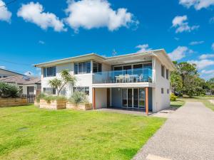a large white house with a lawn in front of it at NRMA Woodgate Beach Holiday Park in Woodgate