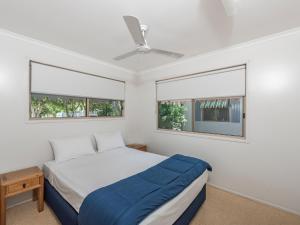 伍德蓋特的住宿－NRMA Woodgate Beach Holiday Park，一间卧室设有一张床和两个窗户。