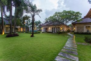 a courtyard of a villa with a lawn at Bali Breezz Hotel in Jimbaran