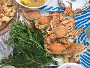a tray of crabs on a table with other foods at Koh Phaluai Beach Bangalow in Koh Phaluai