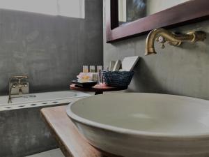 een badkamer met een witte wastafel en een spiegel bij Coza Ceylon in Mount Lavinia