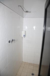 a bathroom with a shower with white tiles at The Lakes Hotel in The Entrance