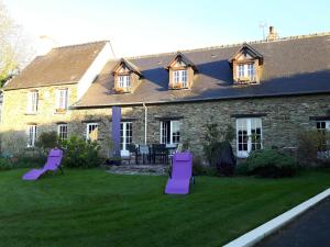 une maison avec des chaises de jardin pourpres devant elle dans l'établissement L'Anctovillière, à Anctoville