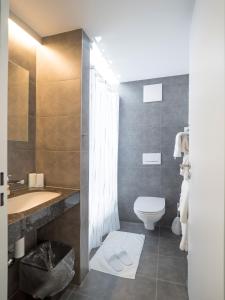Aparthotel Bären في Seengen: حمام مع حوض ومرحاض وحوض استحمام