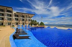 een hotel met een groot zwembad aan de oceaan bij The Bellevue Resort in Panglao