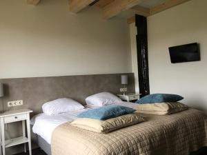 a bedroom with a bed with two pillows on it at Hotel Posthuys Vlieland in Oost-Vlieland