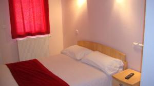 a bedroom with a bed with a red window at Auberge De Peyrebeille in Lanarce