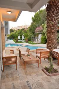 une terrasse avec des chaises et des tables, ainsi qu'une piscine. dans l'établissement Calis Hotel, à Çeşme