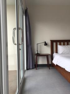 a bedroom with a bed and a lamp on a table at The 9th House in Krabi town