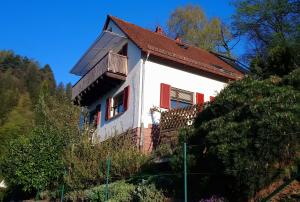 a white house with red windows on a hill at Casa la Collina delle Ginestre in Eberbach