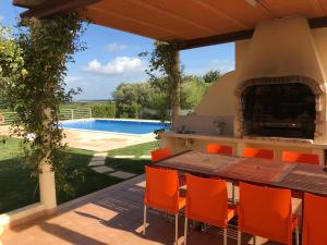 een patio met een tafel en stoelen en een zwembad bij Villa Estrelamar in Boliqueime