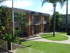 a building with a fence and palm trees at Jadran Motel & El Jays Holiday Lodge in Gold Coast