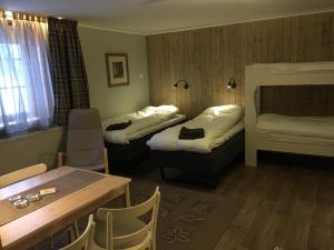 Habitación de hotel con 2 camas y mesa en Knappgården en Särna