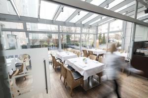 osoba przechodząca przez restaurację ze stołami i krzesłami w obiekcie Prielmayerhof HOTEL w Linzu