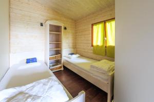um pequeno quarto com 2 camas e uma janela em Les Chalets de Pierretoun em Labastide-Clairence