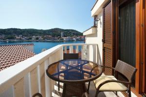 d'une table et de chaises sur un balcon avec vue sur l'eau. dans l'établissement Apartments Tisno - Villa Mare, à Tisno