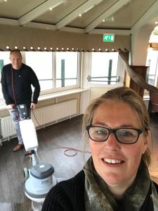 een vrouw met een bril in een kamer met een camera bij Hotel Havenzicht Texel in Oudeschild